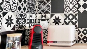 A kitchen with a patterned backsplash, a red appliance, and a white toaster. - Renovated studio 200 m from Rochefort harbour - Your haven of peace in town (Rochefort)