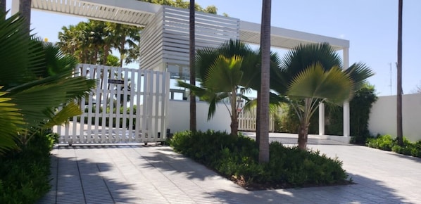 Stroll through the beautifully landscaped grounds, lined with palm trees and a pathway leading to the modern building.