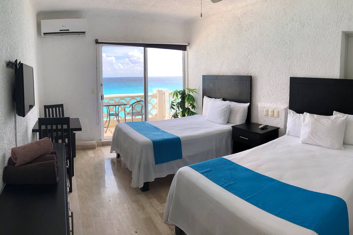 Apartamento luxo, vista para a praia | Cofres nos quartos, escrivaninha, Wi-Fi de cortesia, roupa de cama