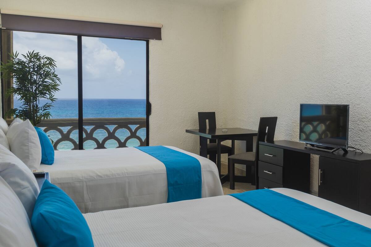 Apartamento luxo, vista para a praia | Cofres nos quartos, escrivaninha, Wi-Fi de cortesia, roupa de cama