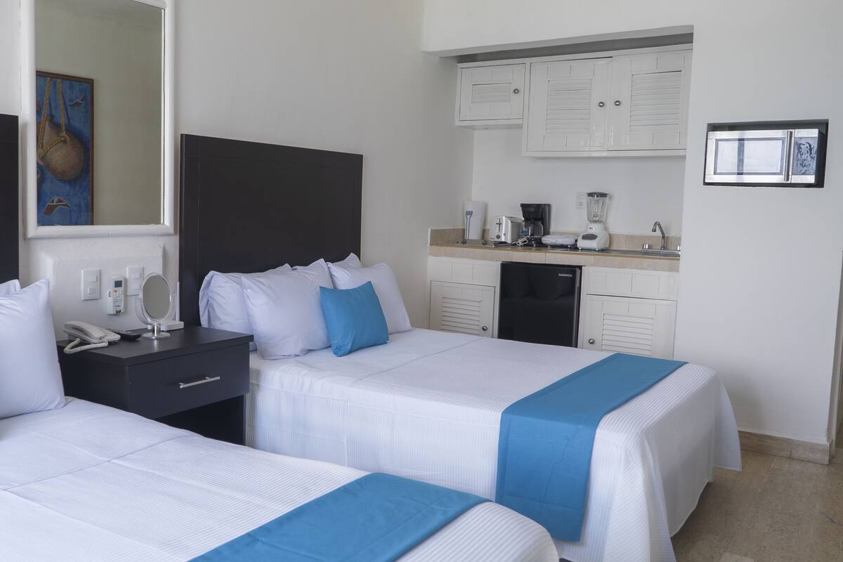 Apartamento família, vista para a praia | Cofres nos quartos, escrivaninha, Wi-Fi de cortesia, roupa de cama