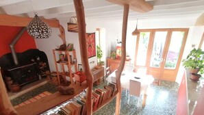 Una habitación acogedora con chimenea, estantes de madera, una mesa de comedor y vistas al exterior.