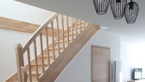 Een moderne keuken met een houten trap, een inbouwwerkbank en hanglampen.