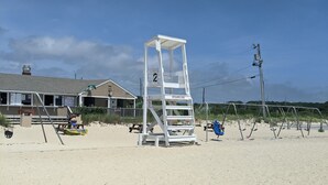 Een strandwachtpost op een zandstrand, met een heldere lucht.