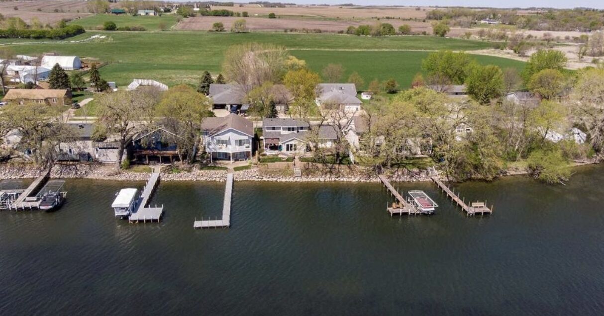 An aerial view of a lakeside property with multiple docks and houses.