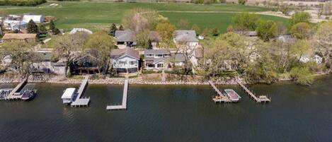 An aerial view of a lakeside property with multiple docks and houses.