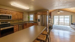 Une cuisine spacieuse dotée de meubles en bois, d’appareils électroménagers en acier inoxydable et d’un grand îlot central.