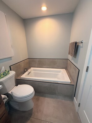 Une salle de bain avec une baignoire, des toilettes et un porte-serviettes.