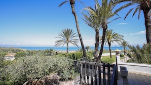 A coastal view with palm trees and a clear sky. - 030 Villa Marines (Denia)