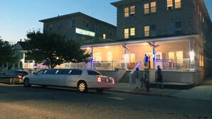 A hotel with a prominent entrance, a staircase leading to the main building, and a car parked in front. - Half Block from Belmar Beach!! (Belmar)
