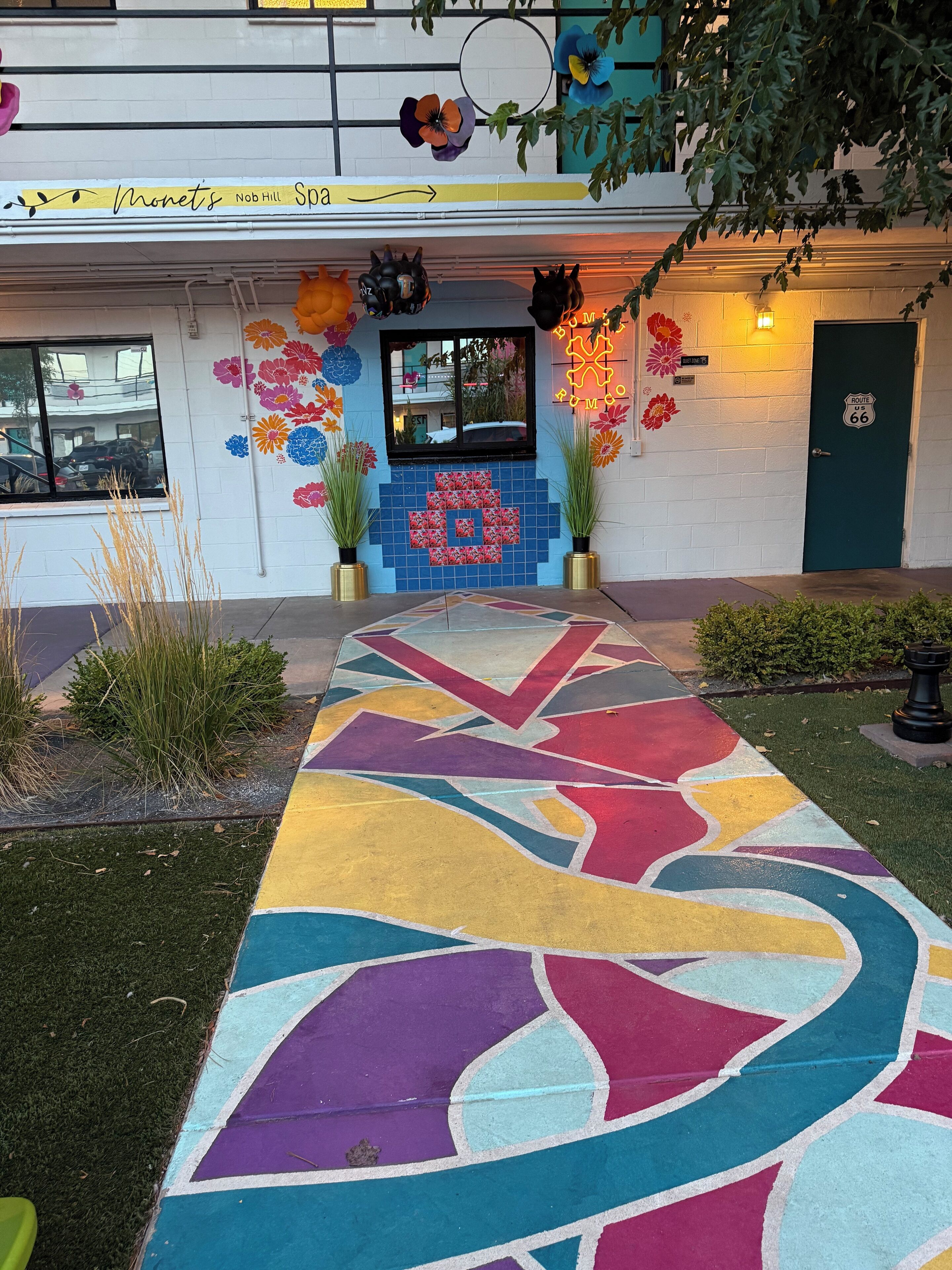 A colorful pathway leading to a building with a sign reading "Monet's Nob Hill Spa."
