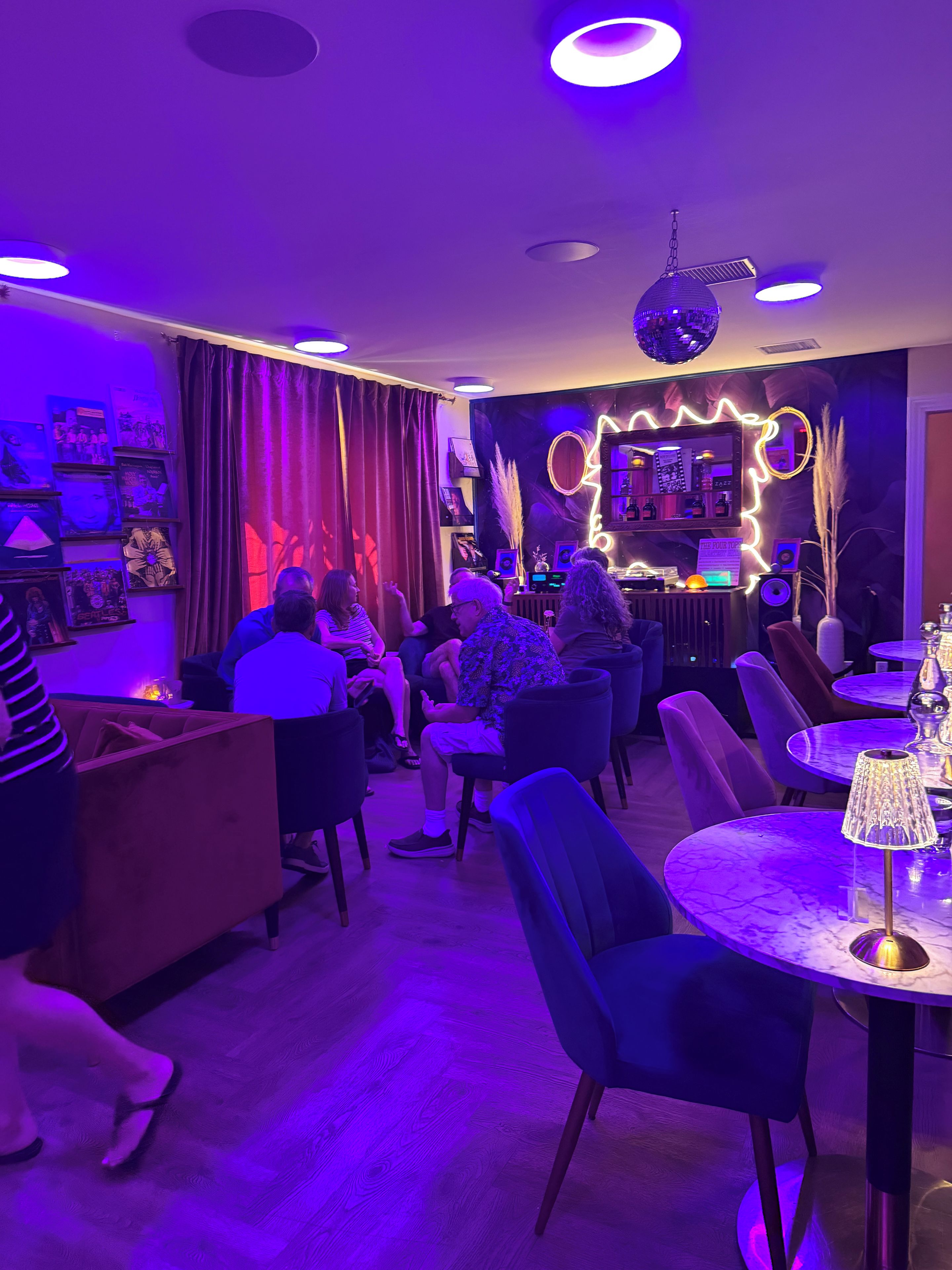 Ein Raum mit Bar, Sitzgelegenheiten und einer Discokugel.