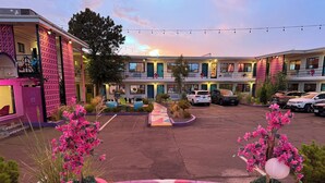 A hotel with a central courtyard, multiple balconies, and a parking area. - Hotel Zazz (Albuquerque)