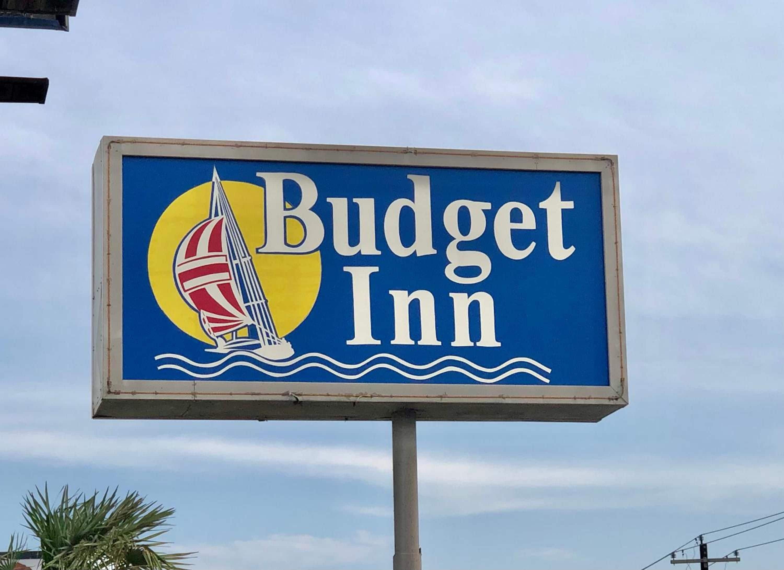 A sign for Budget Inn with a sailboat illustration.