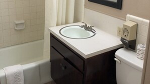 Une salle de bain équipée d’une baignoire, de toilettes, d’un lavabo et d’un miroir.