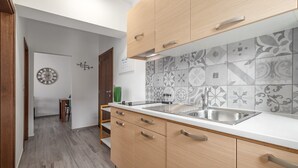 A modern kitchen with wooden cabinets, a stainless steel sink, and patterned backsplash tiles. - Oroz / Apartment Oroz I (Porec)