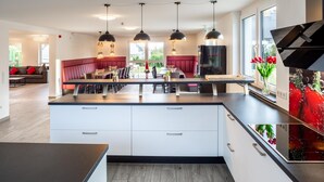Una cocina moderna con una isla central, iluminación colgante y vistas al exterior.