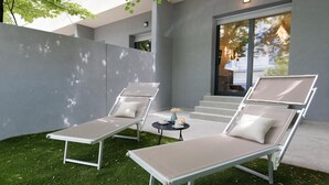 Two lounge chairs with cushions, a small table with a vase and a cup, and a staircase leading to a building. - Bosket Luxury Rooms (Split)