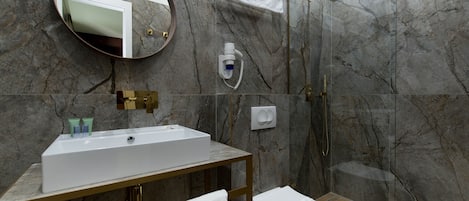 A modern bathroom with a marble wall, a sink, a toilet, a shower, and a mirror.