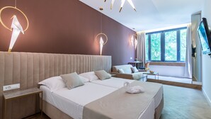 A modern hotel room with a large bed, a sofa, a desk, and a TV. - Bosket Luxury Rooms (Split)