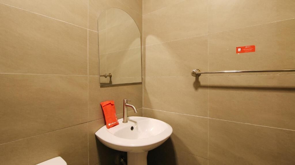 A bathroom with a white sink, a mirror, and a towel rack.