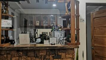 A reception area with a stone counter, wooden wheel decorations, a television above, and a door to the right.