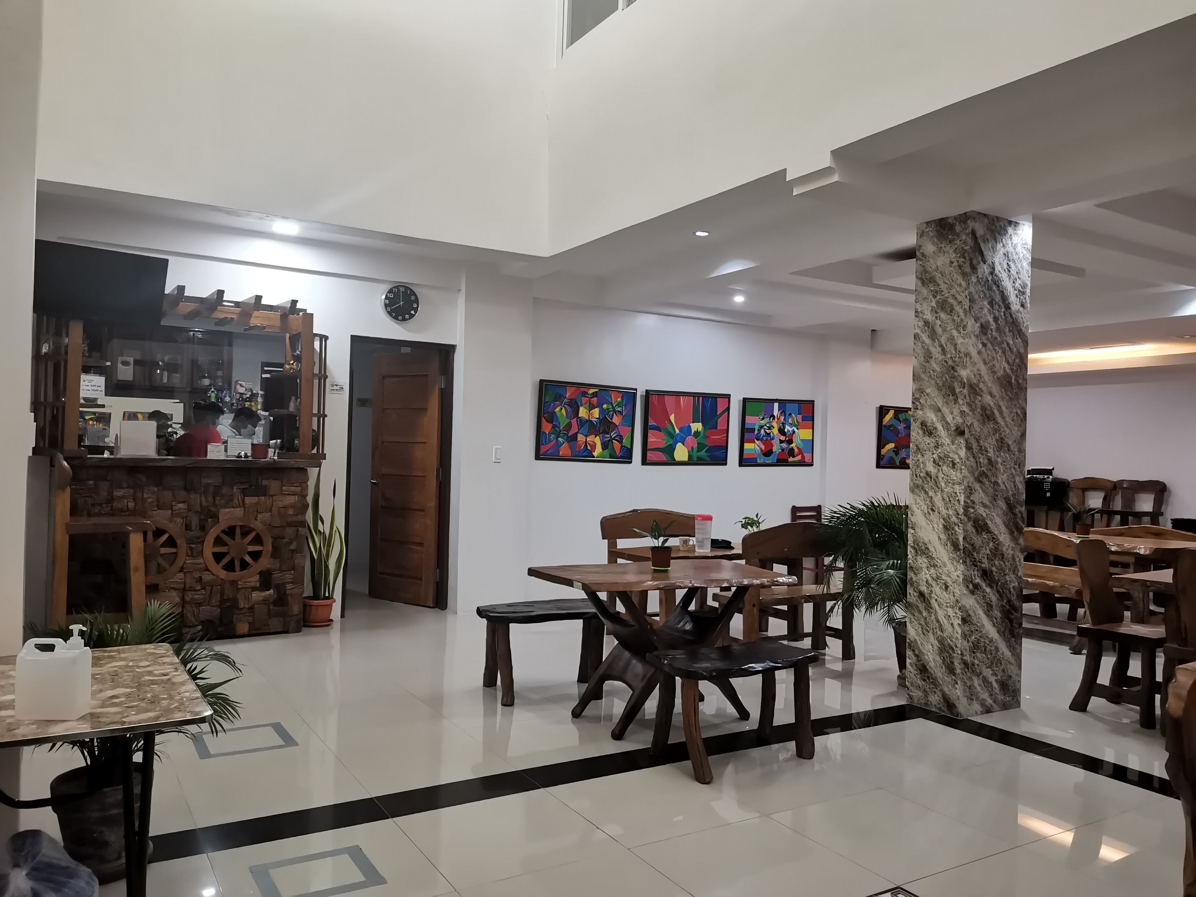 Un hall d’entrée spacieux avec un bar à café, un coin salon et des œuvres d’art exposées sur les murs.