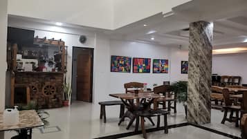Un hall d’entrée spacieux avec un bar à café, un coin salon et des œuvres d’art exposées sur les murs.