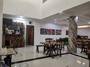 Un hall d’entrée spacieux avec un bar à café, un coin salon et des œuvres d’art exposées sur les murs.