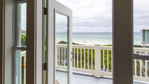 Vista desde una habitación con un amplio ventanal que da a la playa y al océano.