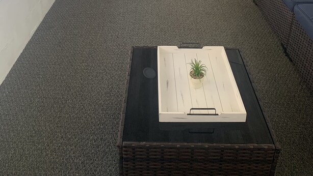 Ein gemütliches Wohnzimmer mit einer Couch, Sesseln, einem Couchtisch und Blick durch eine Glastür.