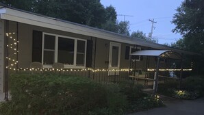 Ein Gebäude mit einer überdachten Veranda und Lichterketten an der Fassade.