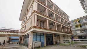 Un edificio a più piani con balconi, un ingresso coperto e un cartello che indica un ristorante.