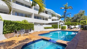 A modern hotel with a swimming pool, outdoor seating, and lush greenery. - Cote D'Azur 4 Sunshine Beach (Sunshine Beach)