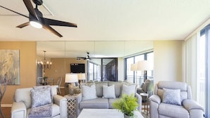 A modern living room with a sofa set, a coffee table, and a ceiling fan.