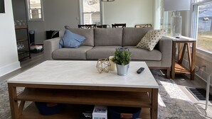 Ein Wohnzimmer mit einer Couch, einem Couchtisch und einem Fenster mit Blick.