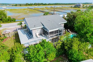 A two-story house with a large deck, a swimming pool, and a view of a water body. - Hot tub, Private Pool, Pet Friendly, Sunset Views! - 600 Palm (Isle Of Palms)