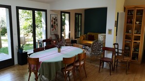Un comedor con una mesa redonda, sillas y una estantería.