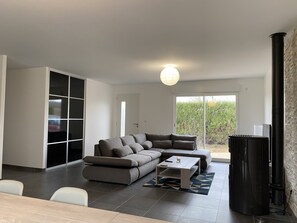 Un salon moderne avec un canapé d’angle, une table basse et une cheminée.