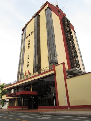 A hotel named "HOTEL DON LOLO" with a yellow facade, large windows, and a red and yellow trim. - Hotel Don Lolo (Villavicencio)