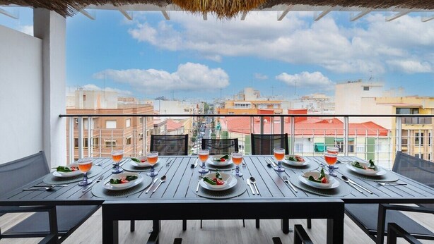 A balcony with a table set for four, overlooking a cityscape. - Fidalsa Penthouse Amazing View (Alicante)