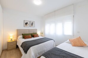 A hotel room with a bed, bedside table, lamp, and artwork on the wall. - Fidalsa Penthouse Amazing View (Alicante)