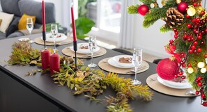 A dining table set with candles, plates, and a Christmas tree decoration. - Fidalsa Penthouse Urban Sea View (Alicante)