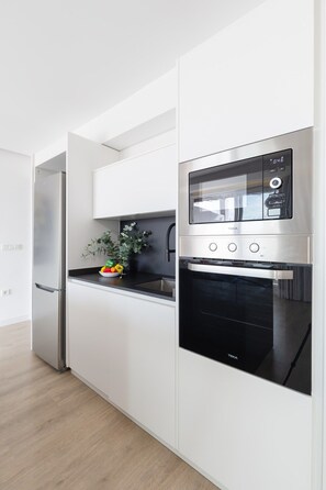Eine moderne Küche mit Backofen, Kühlschrank und Spüle.