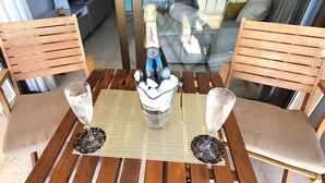A wooden table with a bottle of champagne, two glasses, and a coaster. - Magnificent 10th-Floor Studio with Sea Views (Marbella)