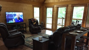 Una sala de estar acogedora con un sofá de cuero, un televisor y detalles de madera.