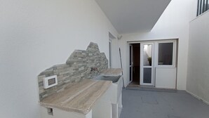 A narrow hallway with a stone wall, a sink, and a door leading to a room. - Marina di Leuca Apartment (Marina di Leuca)