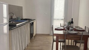 A modern kitchen with a dining area. - Marina di Leuca Apartment (Marina di Leuca)