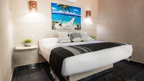 Une chambre à coucher bien rangée, avec un lit, des tables de chevet, un climatiseur fixé au mur et un tableau sur le thème des pays tropicaux.