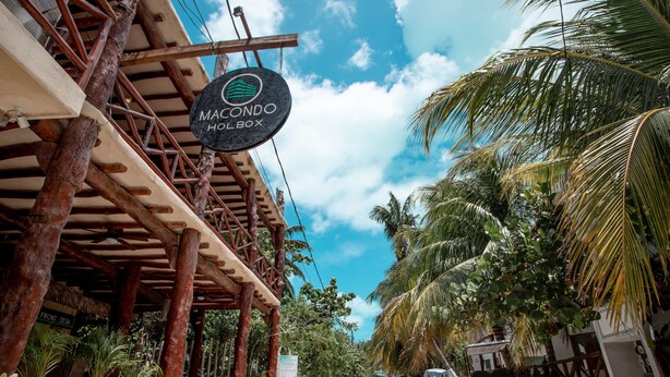 Une structure en bois sur laquelle est apposée une enseigne indiquant « MACONDO HOTEL BOX ».